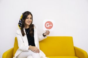 The girl is smiling and showing google+ logo.
